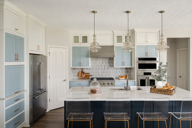 Mid-sized trendy l-shaped medium tone wood floor eat-in kitchen photo in Indianapolis with an undermount sink, shaker cabinets, blue cabinets, quartz countertops, stainless steel appliances, an island and white countertops