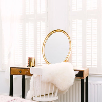 A rustic bedroom with a touch of blush and brass