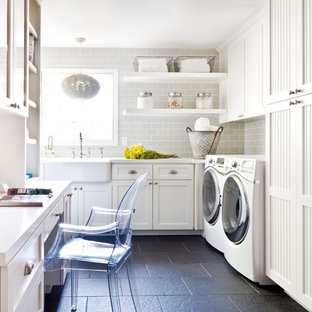 This is an example of a small traditional u-shaped utility room in San Francisco with a belfast sink, shaker cabinets, white cabinets, engineered stone countertops, slate flooring, a side by side washer and dryer, grey walls, grey floors and white worktops.