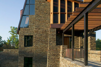 Inspiration for a large contemporary three-storey grey exterior in Minneapolis with stone veneer and a gable roof.
