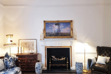 Inspiration for a medium sized classic open plan living room in Other with beige walls, medium hardwood flooring, a standard fireplace, a plastered fireplace surround, a concealed tv and brown floors.