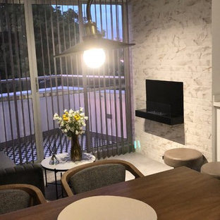 Aménagement d'une salle à manger éclectique avec cheminée suspendue et un manteau de cheminée en brique.