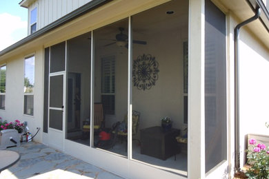 Example of a mid-sized classic backyard stone patio design in Other with a roof extension