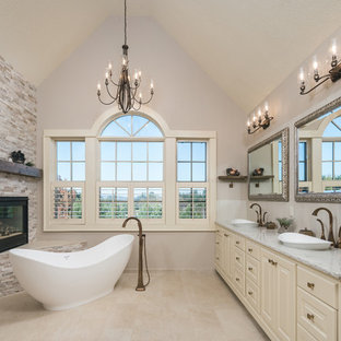 Inspiration for a timeless master beige floor freestanding bathtub remodel in Portland with raised-panel cabinets, beige cabinets, gray walls, a vessel sink and gray countertops