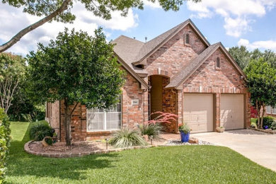 Mid-sized elegant red two-story mixed siding house exterior photo in Dallas with a hip roof and a shingle roof