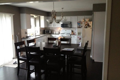Eat-in kitchen - modern u-shaped eat-in kitchen idea in Detroit with shaker cabinets, white cabinets, granite countertops, white backsplash, subway tile backsplash and white appliances