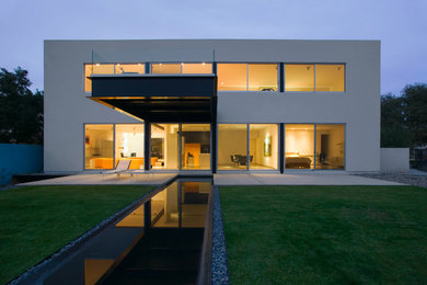 Inspiration for a large contemporary two-storey white house exterior in Phoenix with a flat roof.