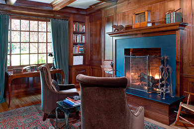 Mid-sized elegant enclosed dark wood floor and brown floor living room library photo in Los Angeles with brown walls, a standard fireplace, a stone fireplace and no tv