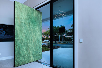 他の地域にある広いコンテンポラリースタイルのおしゃれな玄関ドア (白い壁、磁器タイルの床、緑のドア、ベージュの床) の写真