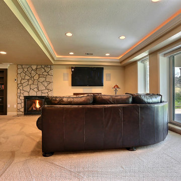 Open Basement Concept in Centennial, CO with tray ceilings and stacked stone