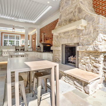 Outdoor kitchen and stone fireplace open to the indoor kitchen via NanaWall fold