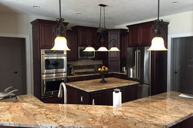 Eat-in kitchen - mid-sized traditional porcelain tile eat-in kitchen idea in Boston with raised-panel cabinets, dark wood cabinets, granite countertops, beige backsplash, ceramic backsplash, stainless steel appliances, an island and a double-bowl sink