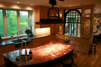 Eat-in kitchen - mid-sized rustic l-shaped medium tone wood floor eat-in kitchen idea in Cleveland with a farmhouse sink, recessed-panel cabinets, light wood cabinets, terrazzo countertops, white backsplash, subway tile backsplash, stainless steel appliances and an island