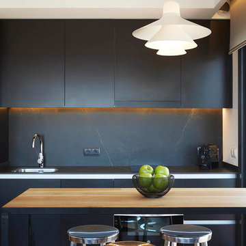 Cocina en color negro con mesa de madera natural - Coblonal Interiorismo