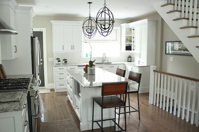 Inspiration for a mid-sized transitional u-shaped open plan kitchen in Toronto with shaker cabinets, white cabinets, granite benchtops, white splashback, stainless steel appliances and with island.