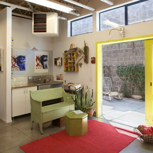 Inspiration for a mid-sized eclectic entryway in San Francisco with white walls, concrete floors, a sliding front door and a yellow front door.