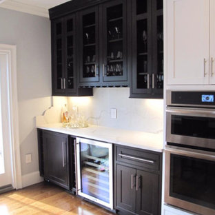ボストンの中サイズのモダンスタイルのおしゃれなウェットバー (ガラス扉のキャビネット、黒いキャビネット、珪岩カウンター、白いキッチンパネル、セラミックタイルのキッチンパネル、淡色無垢フローリング、ベージュの床) の写真