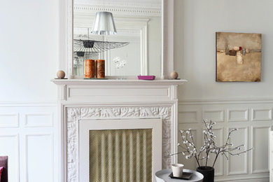 Inspiration pour un salon design de taille moyenne et ouvert avec un mur gris, parquet foncé, une cheminée standard, un manteau de cheminée en pierre et aucun téléviseur.