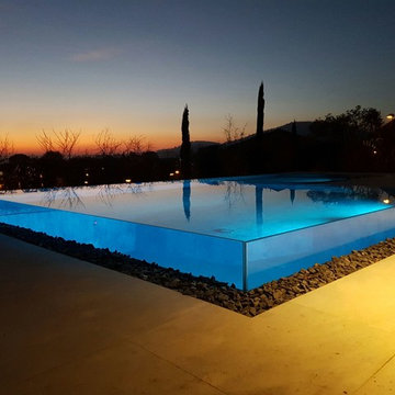Piscina residenziale esterna con parete in vetro