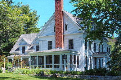 Example of a large classic white two-story wood gable roof design in Portland Maine