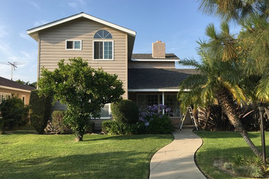 Mid-sized traditional beige two-story vinyl house exterior idea with a hip roof and a shingle roof