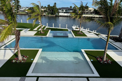 Large minimalist backyard stone and rectangular pool landscaping photo in Miami