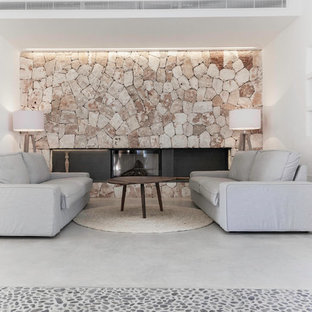 Repräsentatives, Mittelgroßes, Abgetrenntes Mediterranes Wohnzimmer mit weißer Wandfarbe, Betonboden, Gaskamin und Kaminsims aus Stein in Palma de Mallorca