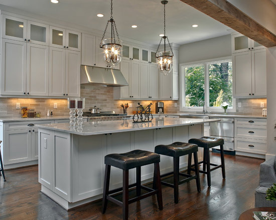 Large traditional open concept kitchen remodeling - Example of a large classic l-shaped dark wood floor open concept kitchen design in Atlanta with a farmhouse sink, shaker cabinets, white cabinets, marble countertops, gray backsplash, stainless steel appliances and an island