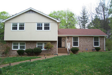 Example of a beige split-level brick gable roof design in Nashville