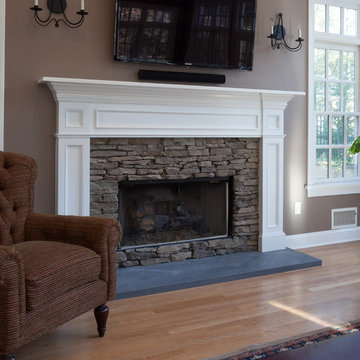 Fireplace mantle in white with stacked stone surround set a top volcanic stone a