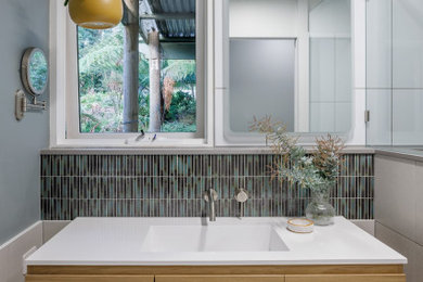 Inspiration for a small contemporary 3/4 bathroom in Melbourne with light wood cabinets, an alcove shower, a one-piece toilet, white tile, mosaic tile, green walls, porcelain floors, a wall-mount sink, solid surface benchtops, grey floor, an open shower, white benchtops, a floating vanity and flat-panel cabinets.
