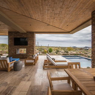 フェニックスの大きいコンテンポラリースタイルのおしゃれな裏庭のテラス (タイル敷き、張り出し屋根、屋外暖炉) の写真