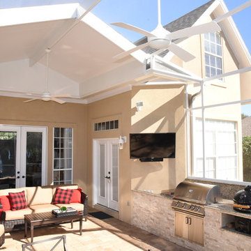 Outdoor kitchen with extended roof and screen enclosure