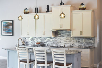 Imagen de cocina tradicional renovada de tamaño medio con encimera de granito, salpicadero verde, salpicadero de azulejos de vidrio, una isla y encimeras grises