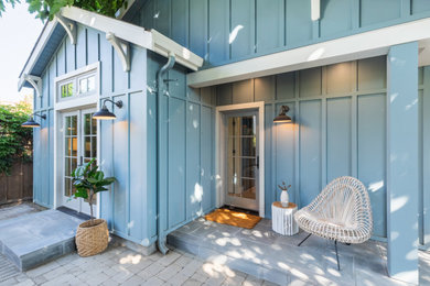 Small craftsman blue one-story wood and board and batten exterior home idea in San Francisco with a shingle roof and a black roof