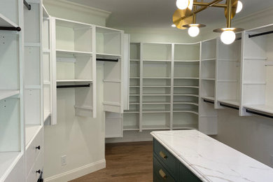 Imagen de armario vestidor clásico renovado grande con armarios abiertos, puertas de armario blancas, suelo de madera en tonos medios y suelo marrón