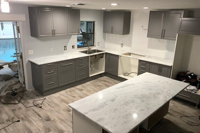 Example of a large country l-shaped vinyl floor and gray floor eat-in kitchen design in Tampa with a drop-in sink, shaker cabinets, gray cabinets, quartzite countertops, an island and white countertops