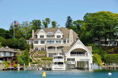 Huge arts and crafts yellow three-story mixed siding exterior home photo in Other with a shingle roof