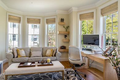 Photo of a large transitional study room in Boston with beige walls, medium hardwood floors, no fireplace, a freestanding desk and brown floor.