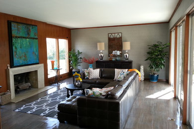Minimalist porcelain tile living room photo in Other with a stone fireplace