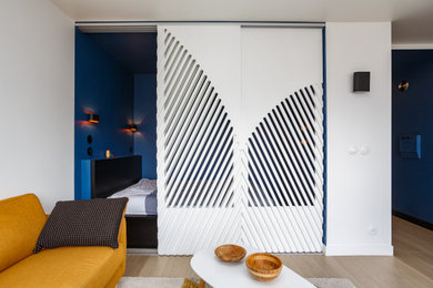 Exemple d'une petite chambre scandinave avec un mur bleu, parquet clair et un sol marron.