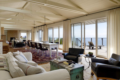Inspiration for a large coastal medium tone wood floor and brown floor great room remodel in San Francisco with white walls, a standard fireplace and a stone fireplace