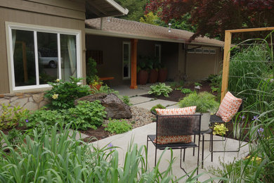 Large modern front yard shaded garden in Portland with a garden path and concrete pavers for spring.