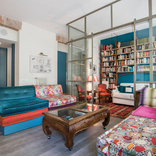 Immagine di un soggiorno etnico con libreria, pareti blu e pavimento grigio