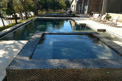 Hot tub - large craftsman backyard stone and custom-shaped natural hot tub idea in Houston