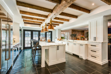 Mid-sized country galley eat-in kitchen in Philadelphia with an undermount sink, shaker cabinets, marble benchtops, stainless steel appliances, slate floors, with island, white benchtop and exposed beam.