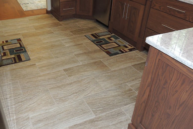 Inspiration for a mid-sized contemporary galley porcelain tile and beige floor kitchen remodel in Chicago with an undermount sink, shaker cabinets, dark wood cabinets, quartz countertops and stainless steel appliances
