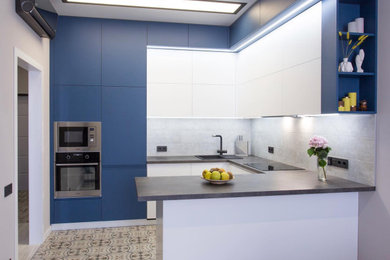 モスクワにある高級な中くらいなコンテンポラリースタイルのおしゃれなキッチン (ドロップインシンク、フラットパネル扉のキャビネット、青いキャビネット、グレーのキッチンパネル、石タイルのキッチンパネル、シルバーの調理設備、セメントタイルの床、ベージュの床、黒いキッチンカウンター、折り上げ天井) の写真