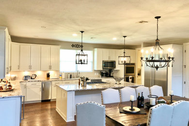Eat-in kitchen - large cottage l-shaped eat-in kitchen idea in Houston with shaker cabinets, white cabinets, granite countertops, stainless steel appliances and an island
