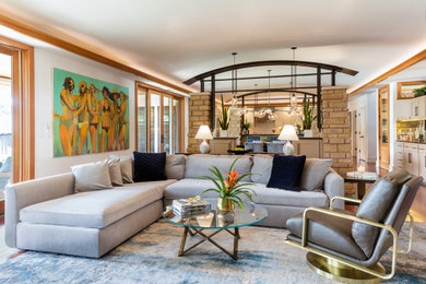 Imagen de sala de estar abierta contemporánea grande con paredes blancas y suelo de madera en tonos medios